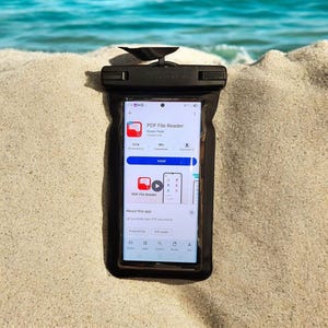 May include: A black waterproof smartphone pouch with a clear front window containing a smartphone displaying the PDF File Reader app store page. The pouch features a secure top locking mechanism and a black lanyard attachment at the top center.