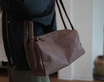 Bolsa de ombro vintage em couro: tamanho grande, alça de couro, design redondo.