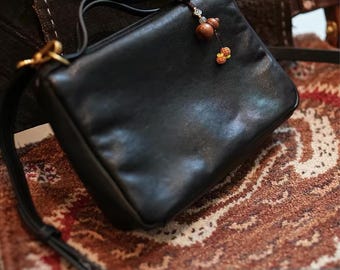 Bolsa transversal em couro bovino: design multicolorido, marrom e preta, alça longa.
