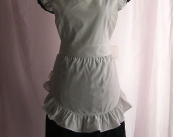 May include: A white apron with a ruffled hem and sleeves. The apron has a black waistband and is worn over a black skirt.