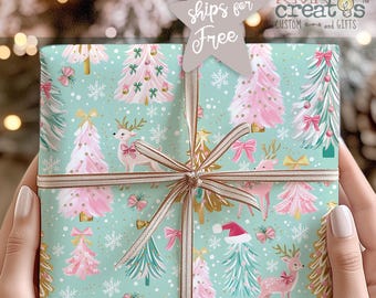 May include: A square gift box wrapped in light blue paper featuring a repeating pattern of pink and white Christmas trees, reindeer, snowflakes, and bows. The package is tied with a thin, metallic gold ribbon and topped with a star-shaped tag.