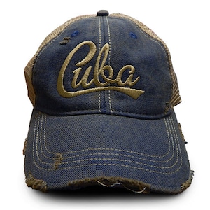 May include: A blue and brown distressed trucker hat with the word "Cuba" embroidered in gold on the front.