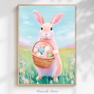 Puede incluir: Una impresión enmarcada que presenta un conejo rosa sosteniendo una cesta de huevos de Pascua coloridos. El conejo está en un campo de hierba verde y flores, con un cielo azul y colinas rosas en el fondo. La impresión está firmada "Wisterelle Prints".
