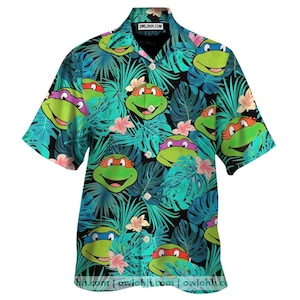 May include: Short-sleeved button-down shirt featuring a vibrant pattern of cartoon turtle faces and tropical foliage in shades of green, blue, and pink. The shirt has a classic collar and the text "OWLOHH.COM" on the collar.