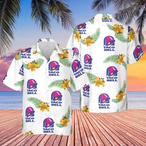 May include: White button-down shirt featuring a repeating pattern of the Taco Bell logo, yellow flowers, and green leaves. The shirt has short sleeves and a relaxed fit, perfect for a casual look. The Taco Bell logo is a purple bell with a pink top.