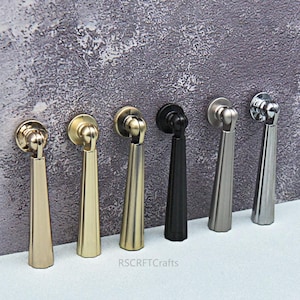 以下が含まれることがあります： 金、真鍮、黒など、さまざまな金属仕上げの6つのキャビネットプル。 各プルは、円形のバックプレートと涙の形をしたハンドルを備えており、家具にエレガントさを加えるのに最適です。