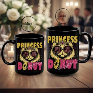 以下が含まれることがあります： 「PRINCESS DONUT」の文字とサングラスと王冠をつけた猫が描かれた、黒いセラミックマグカップ2つ。マグカップは312mlと425mlです。猫のグラフィックは黄色で、テキストは黄色とピンクです。