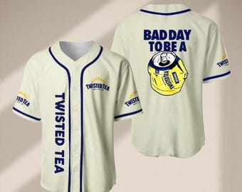 Może przedstawiać: Kremowa koszulka baseballowa z granatowymi wykończeniami. Przód z napisem "TWISTED TEA" w pionie, tył z grafiką zgniecionego puszki i napisem "BAD DAY TO BE A". Logo na rękawach. Swobodny, sportowy element garderoby.
