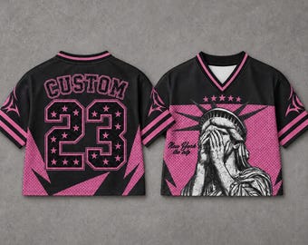 Może przedstawiać: Czarny i różowy krótki jersey ze słowem "CUSTOM" i numerem "23" na plecach. Przód przedstawia grafikę Statuy Wolności z napisem "New York the city".