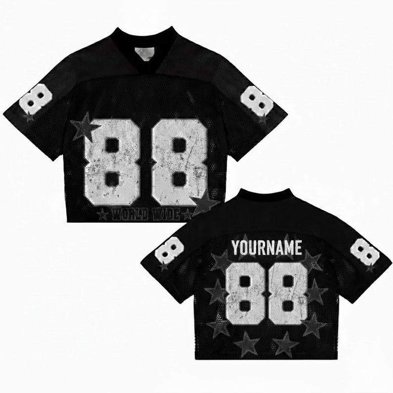May include: Black cropped football jersey with white distressed numbers "88" and star accents. The jersey has a v-neck and mesh fabric. The back of the jersey has the text "YOURNAME" above the number "88". The text "WORLD WIDE" is below the number "88".