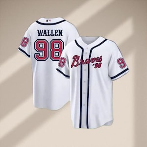 May include: Two white baseball jerseys. One jersey has "WALLEN" and the number "98" in red with a black outline on the back. The other jersey has "Braves '98" in red script on the front and the number "9" on the sleeve.