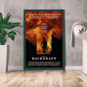 以下が含まれることがあります： 映画「バックドラフト」の額入りポスター。明るいオレンジと黄色の炎に包まれた出入り口に立つ消防士のシルエットが描かれており、上部には白い文字で「BACKDRAFT」のタイトルとキャスト名が記載されています。