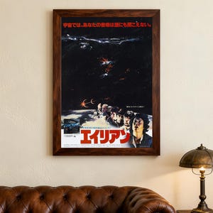 Könnte beinhalten: Gerahmtes Filmplakat mit japanischem Text und dem Titel "Alien" in Rot und Weiß. Das Plakat zeigt eine dunkle Weltraumszene mit einer Gruppe von Menschen, die nach oben blicken. Der Rahmen ist dunkelbraun.