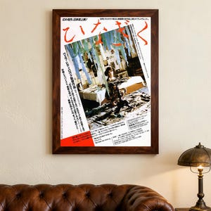 May include: A framed vintage Japanese movie poster in a brown wooden frame. The poster displays Japanese text and an image of two people. It's mounted on a cream wall, above a brown leather sofa and a lamp, creating a retro aesthetic.