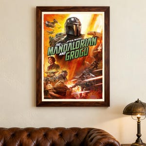 May include: Framed poster of "The Mandalorian and Grogu" from Star Wars. The artwork shows the Mandalorian in his helmet, Grogu, and other characters in an action scene with a fiery background. The poster is in a dark brown wooden frame.