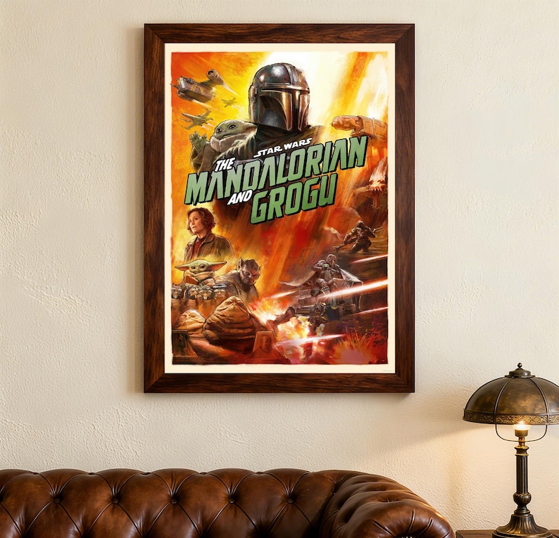 May include: Framed poster of "The Mandalorian and Grogu" from Star Wars. The artwork shows the Mandalorian in his helmet, Grogu, and other characters in an action scene with a fiery background. The poster is in a dark brown wooden frame.