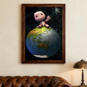 Puede incluir: Impresión enmarcada que muestra un personaje cosido a mano saludando desde la cima de un globo terráqueo detallado. El globo es azul y verde, con continentes bien definidos. El personaje tiene una cara sonriente. El marco es marrón oscuro.
