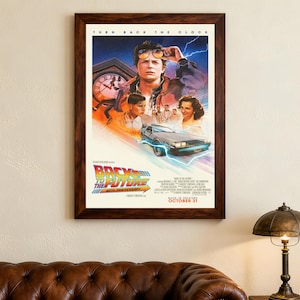 Può includere: Un poster cinematografico incorniciato di "Ritorno al futuro" con una cornice in legno marrone. Il poster presenta il titolo del film, una DeLorean e gli attori. Il testo "TURN BACK THE CLOCK" è in alto. Il poster è su un muro beige.