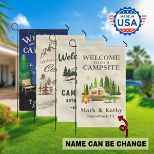 May include: Four outdoor camping garden flags with various designs. One flag says "Welcome to our Campsite" with a camper illustration. Another says "Welcome Camp" with a mountain design. The flags are made in the USA.