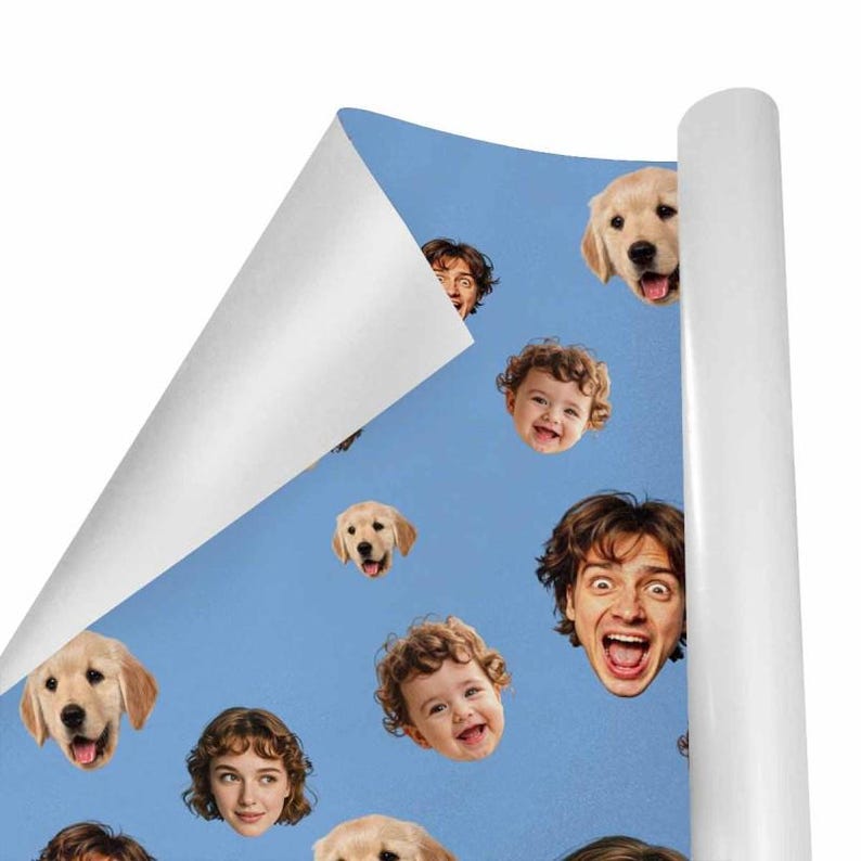 May include: A roll of blue wrapping paper featuring a pattern of smiling faces of babies, dogs, and people. The paper is partially unrolled, revealing a white interior. The faces are in various sizes and expressions.