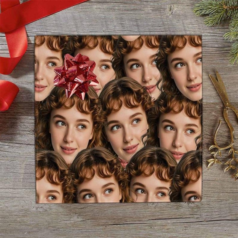 May include: Square gift wrap featuring a repeating pattern of a woman's face with brown hair and a red bow. The background is a wooden surface with red ribbon and gold scissors.