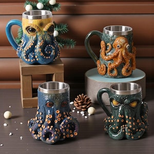 May include: Four ceramic mugs with stainless steel interiors, each featuring an octopus design. The mugs are in shades of blue, green, and orange, with detailed tentacle and eye features. The mugs are on a wooden surface.