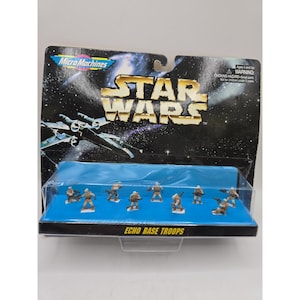 May include: A Star Wars Micro Machines Echo Base Troops toy set in original packaging. The blister pack features a space background with an X-wing fighter and eight small, tan-coloured soldier figurines standing on a bright blue base.