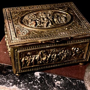 Joyero antiguo con baraja de tarot en miniatura. Caja de metal barroca con escenas renacentistas. Marcado con J B en la parte inferior.