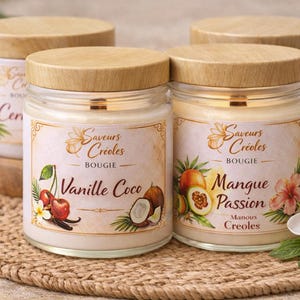 May include: Four glass jar candles with wooden lids. Two jars are in focus, labelled "Vanille Coco" and "Mangue Passion." Each label features illustrations of fruits and flowers. The candles sit on a woven mat.