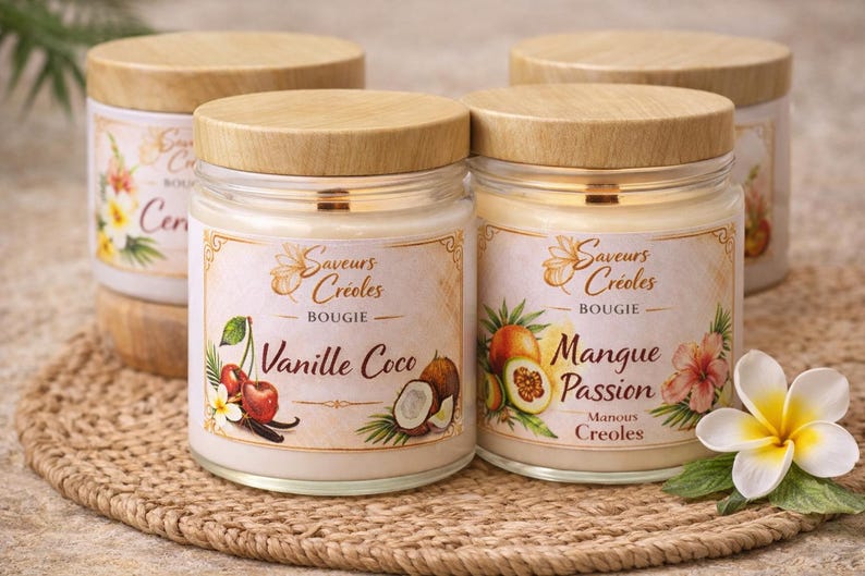 May include: Four glass jar candles with wooden lids. Two jars are in focus, labelled "Vanille Coco" and "Mangue Passion." Each label features illustrations of fruits and flowers. The candles sit on a woven mat.