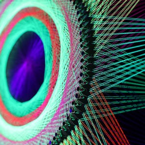 Può includere: Opera d'arte astratta con un design circolare che mostra anelli concentrici in colori vivaci. Il design utilizza verde neon, rosso e viola, creando una composizione dinamica. L'opera è su uno sfondo scuro.