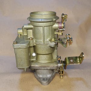 May include: A vintage Carter YF carburetor, in a gold tone, with various levers, screws, and a base. The text "CARTER YF" and "MADE IN U.S.A." are visible. The carburetor is designed for automotive use.