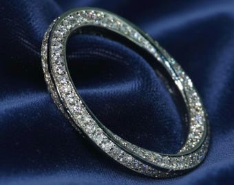 May include: A silver-toned ring featuring a continuous twisted band design. The entire surface of the ring is encrusted with numerous small, clear, sparkling stones that catch the light, creating a brilliant and reflective appearance throughout.