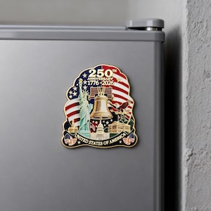 Gold rimmed enamel fridge magnet featuring United States 250th anniversary design 1776-2026, detailed Liberty Bell and Statue of Liberty relief with American flag background.