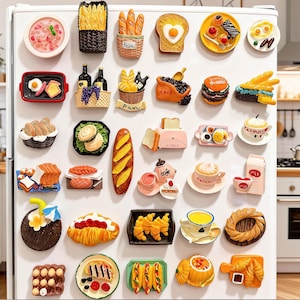 May include: A collection of colorful refrigerator magnets in the shape of various foods. The magnets include bread, pastries, eggs, coffee, and other breakfast and lunch items. The magnets are attached to a white refrigerator door.