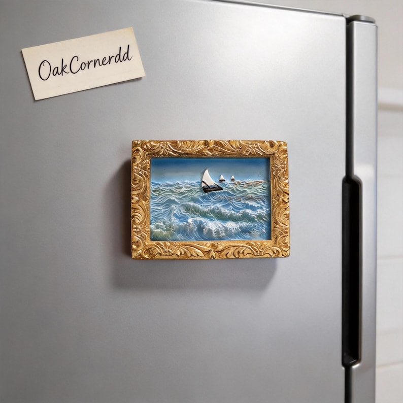 May include: A framed miniature painting of sailboats on a wavy ocean scene. The painting is in a gold ornate frame and is attached to a refrigerator. A small note with the text "OakCornerdd" is also attached to the refrigerator.