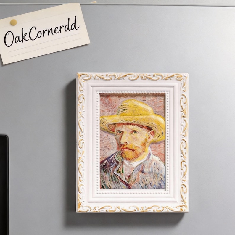 May include: A framed print of Vincent van Gogh in a yellow hat. The white frame has ornate detailing. The print is a reproduction of the artist's self-portrait. A small note with the text "OakCornerdd" is attached to the wall.