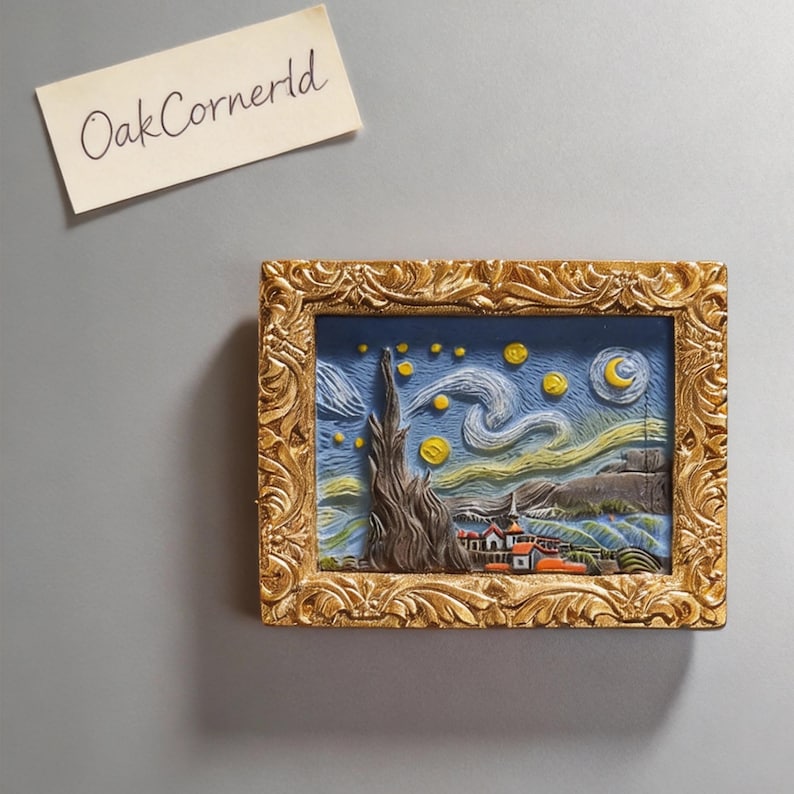 May include: A framed relief sculpture depicting Van Gogh's "Starry Night." The artwork features a gold-colored ornate frame. The painting within the frame shows a blue sky with swirling clouds, stars, and a crescent moon. The text "OakCornerId" is on a separate piece of paper.