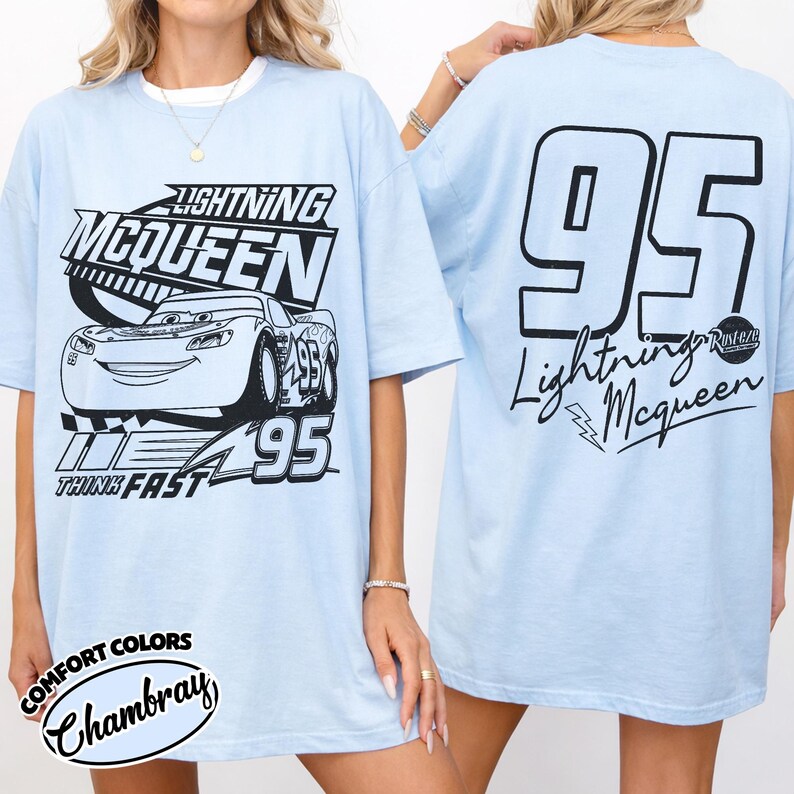 May include: Pale blue t-shirt with a graphic of Lightning McQueen from the film Cars. The front design shows the character, the text "Lightning McQueen," and "95." The back has a large "95" and "Lightning McQueen" with a lightning bolt.