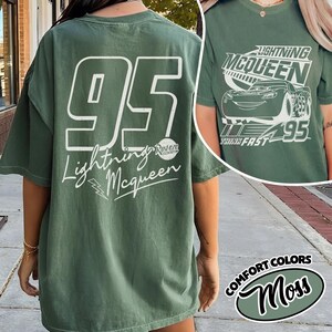 May include: Green t-shirt with the number 95 and the words "Lightning McQueen" in white. The shirt also features a graphic of Lightning McQueen on the front. The shirt is a Comfort Colors Moss colour.