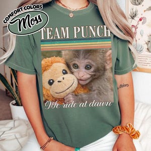 May include: A set of three ceramic mugs with a speckled, matte finish. Each mug features a different color: light blue, cream, and gray. The mugs have a simple, modern design with a rounded shape and a comfortable handle.