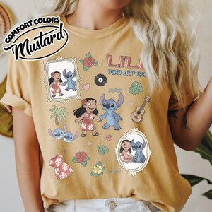 Puede incluir: Camiseta color mostaza con el texto "Lilo and Stitch" y gr&aacute;ficos de dibujos animados de Lilo y Stitch. La camiseta incluye im&aacute;genes de una palmera, flores, una guitarra y un disco.