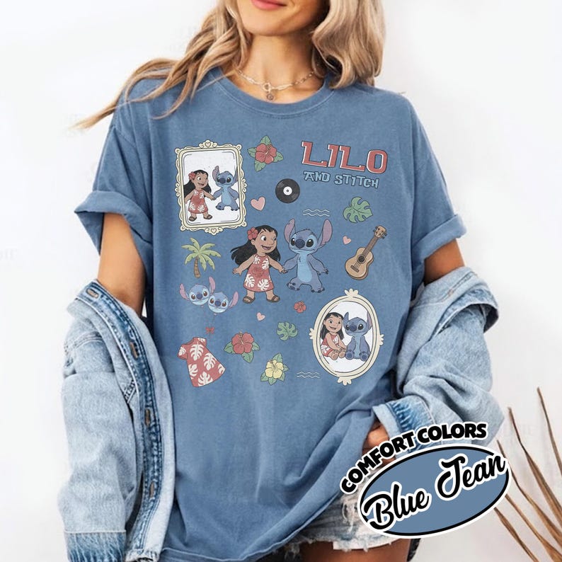 Puede incluir: Camiseta azul vaquero con el texto "Lilo and Stitch" e ilustraciones de dibujos animados de Lilo y Stitch, un ukelele y flores tropicales. La camiseta tiene un corte holgado y mangas enrolladas.