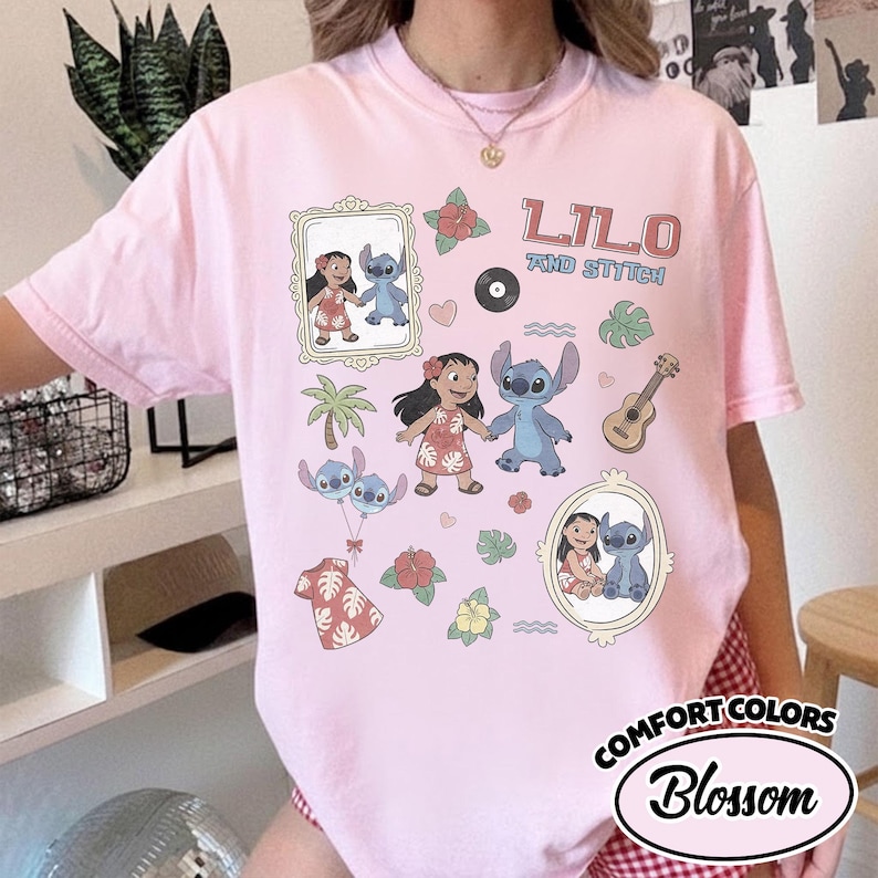 Puede incluir: Una camiseta rosa claro con las palabras "Lilo and Stitch" e ilustraciones de dibujos animados de Lilo y Stitch. La camiseta tambi&eacute;n incluye im&aacute;genes de un ukelele, flores y un disco. La camiseta es de Comfort Colors.