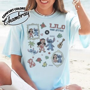 Puede incluir: Camiseta azul claro con las palabras "Lilo and Stitch" e ilustraciones de personajes de dibujos animados. La camiseta tambi&eacute;n tiene las palabras "Comfort Colors Chambray" en un dise&ntilde;o circular.