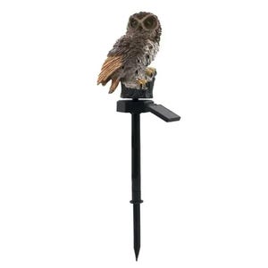 May include: A solar-powered garden stake featuring a detailed owl figurine perched on a tree stump. The owl has brown and tan feathers, with a black solar panel and stake. The stake is designed for outdoor use.