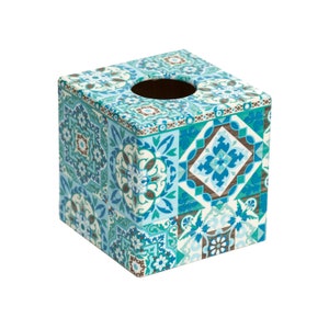 May include: A square tissue box cover with a blue, green and white geometric pattern. The box has a rectangular opening on the top for tissues.