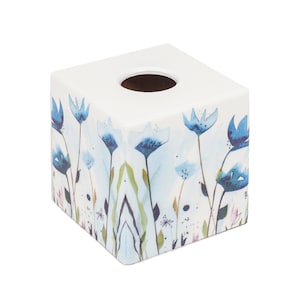 Puede incluir: Tapa de caja de pañuelos de cerámica blanca con un diseño floral azul. El diseño presenta flores azules con centros blancos y hojas verdes sobre un fondo azul claro.