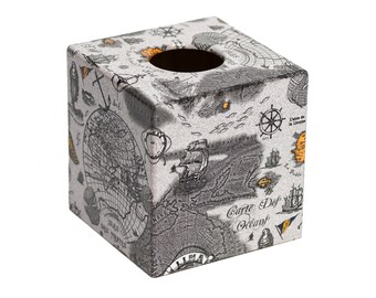 May include: A square tissue box cover with a nautical map design. The cover is made of a light gray material with black and orange details. The box has a rectangular opening on the top for tissues.