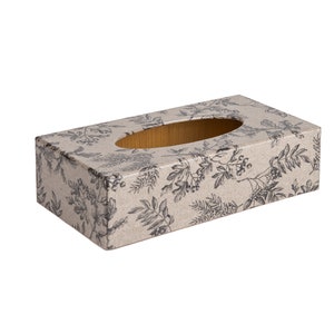 May include: A beige tissue box cover with a black floral pattern. The cover is rectangular in shape with a slot for tissues.